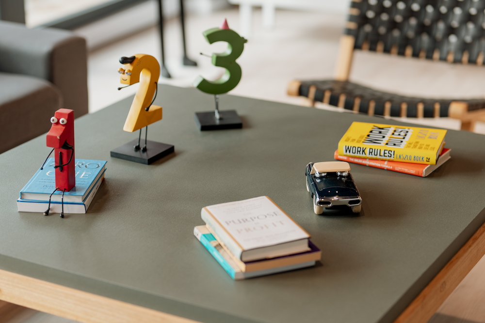 Una mesa de centro con figuras decorativas con forma de los números 1, 2 y 3, así como algunos libros y un pequeño coche de juguete.